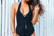 04 a black crocheted one piece lace up swimsuit with tassels and a plunging neckline