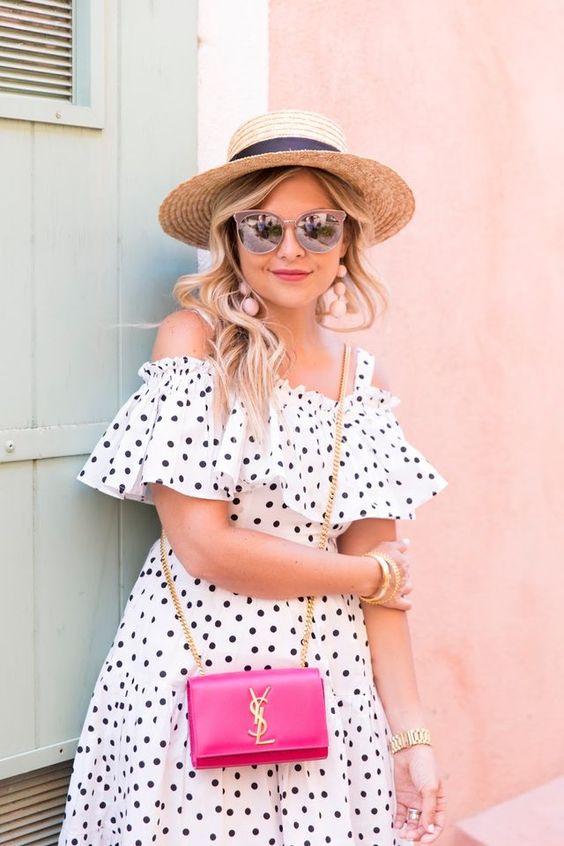 a polka dot cold shoulder mini dress in white and black plus a hat and a pink bag