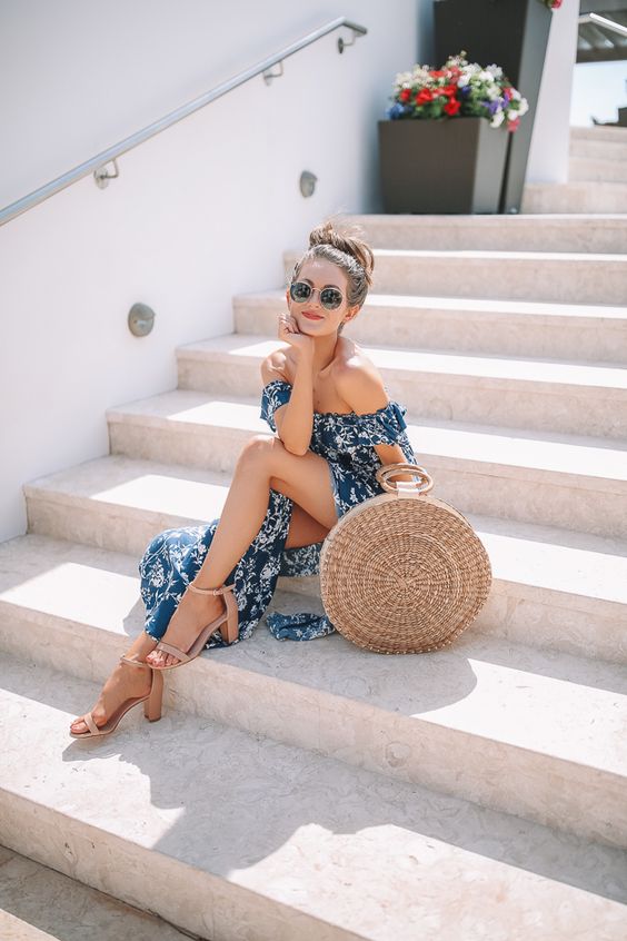 a blue printed off the shoulder midi dress with a slit, a round straw bag and tan shoes