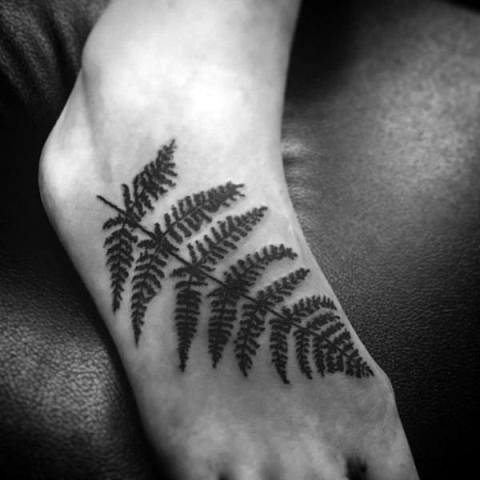Black fern tattoo on the foot