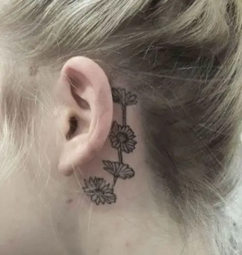 Chain daisy tattoo behind the ear