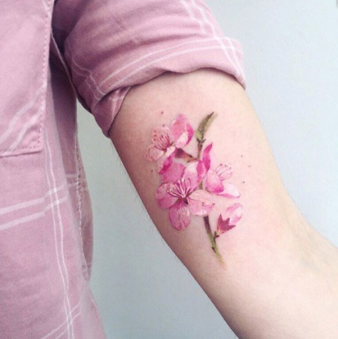 Green and pink tattoo on the arm