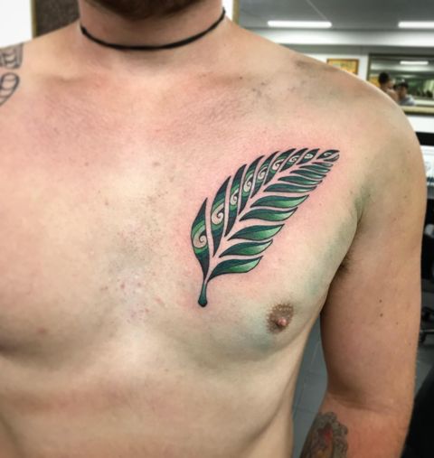Green fern tattoo on the chest
