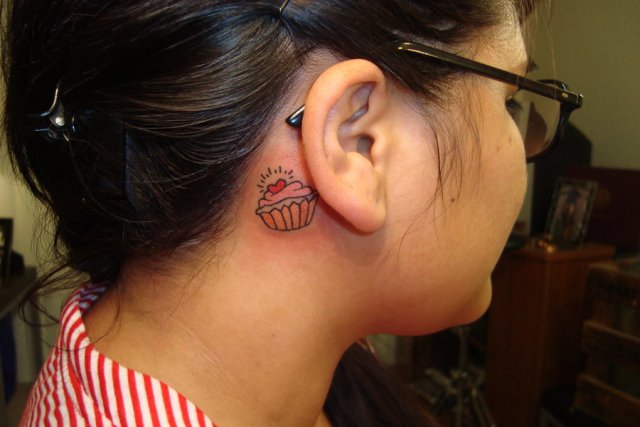 Pink and orange tattoo behind the ear