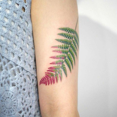 Red and green tattoo on the hand