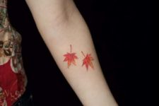 Two orange leaf tattoos on the arm