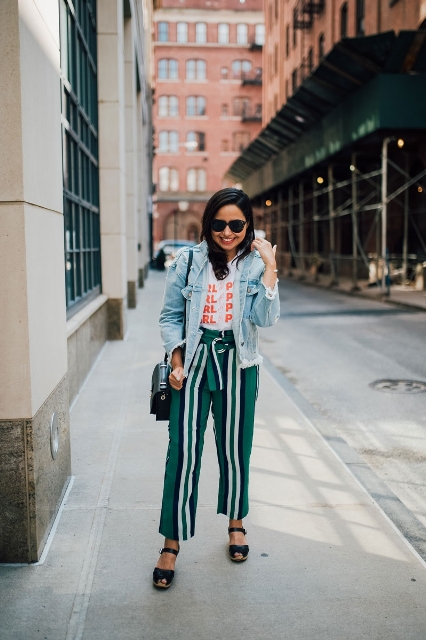 With t-shirt, striped pants, flat sandals and green bag