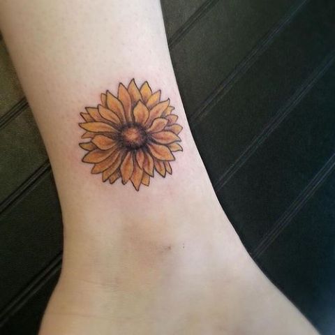 Yellow sunflower tattoo on the leg
