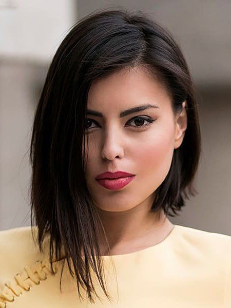 an asymmetrical brunette midi bob with a messy part and textured hair is a catchy idea to try right now