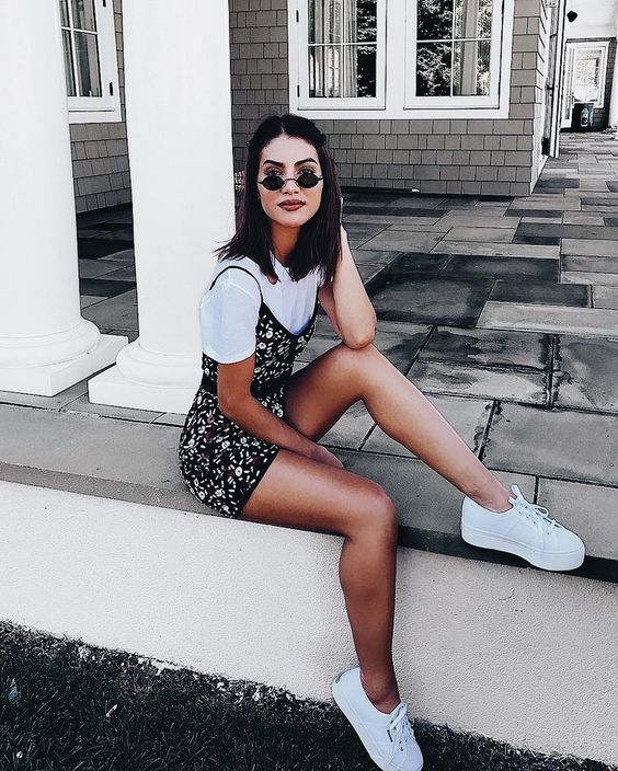 a white tee and a dark floral mini dress over it, white sneakers