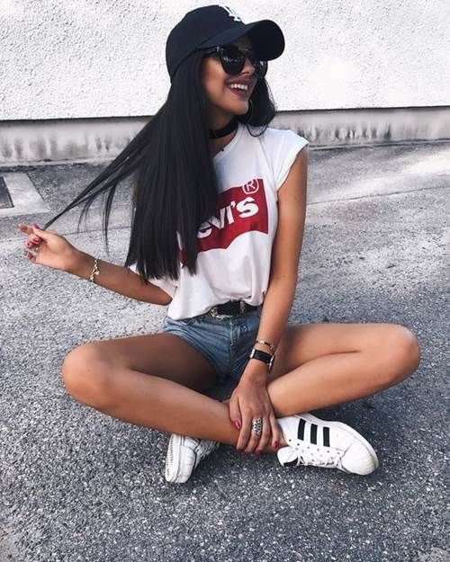 a white Levi's t-shirt, blue denim shorts, white sneakers and a black cap for a sporty look