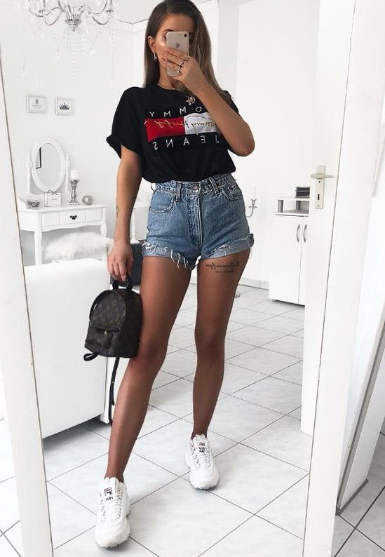 blue denim shorts, a black logo tee, white sneakers and a little black backpack
