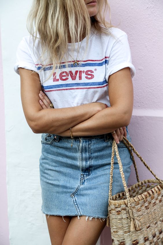 a blue denim mini skirt, a Levi's t-shirt with a logo and a bag