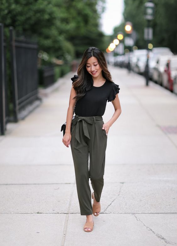 a ruffle sleeve black top, green pants, nude mules and a black bag for a casual work outfit