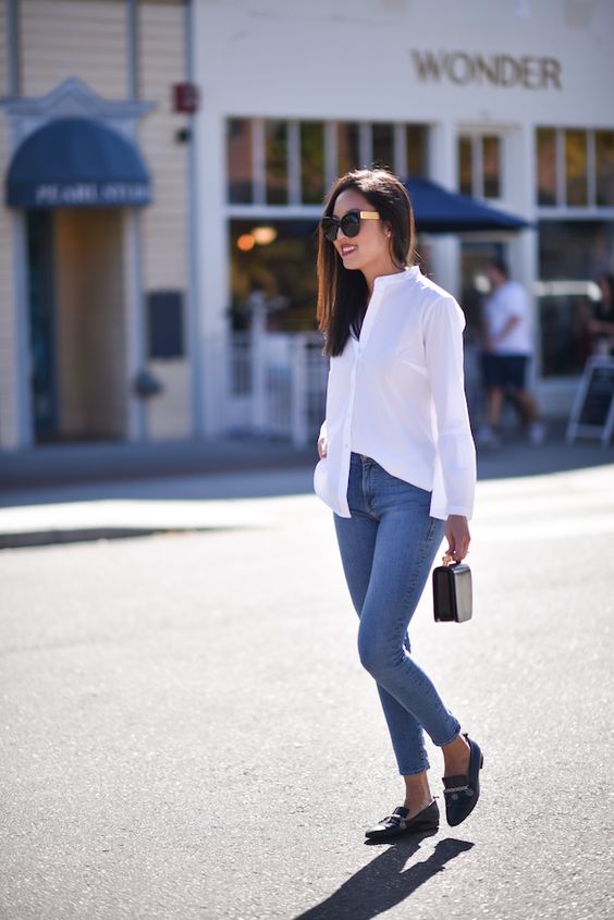 blue cropped jeans, a white shirt, black moccasins and a small black bag