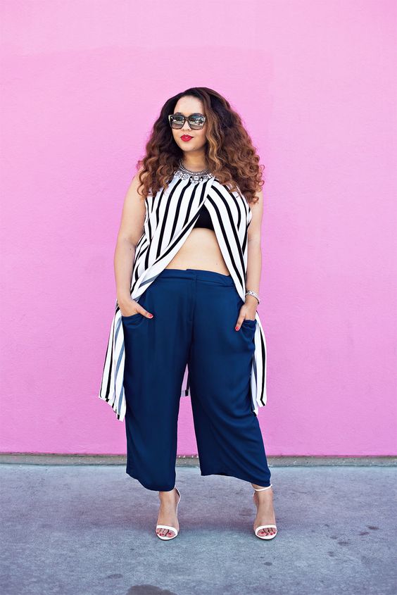 navy culottes, a black bra, a striped long top with a necklace and white heels for a summer party