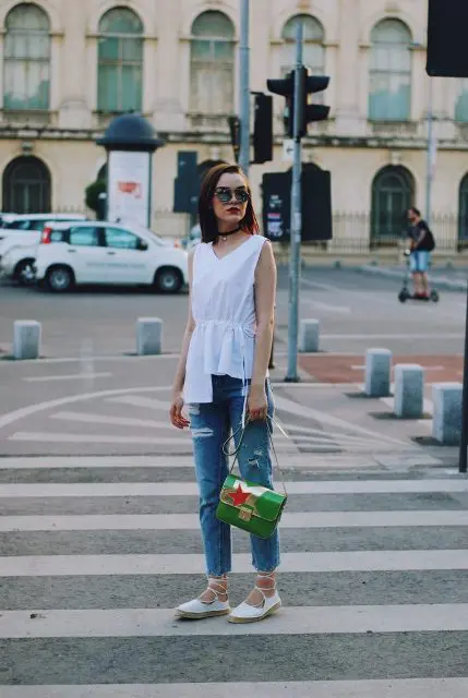 With assymetrical top, jeans and green bag