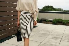 With beige loose blouse, beige pumps and black bag