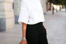 With black high-waisted trousers, black and white high heels and small clutch