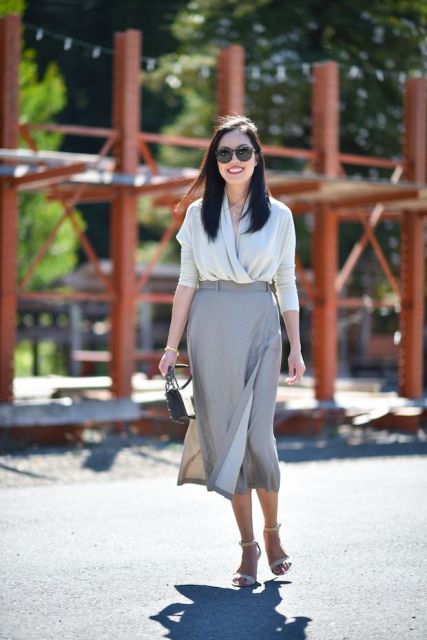 With gray wrapped skirt, sandals and mini bag