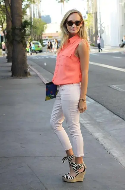 With peach shirt, white pants and clutch