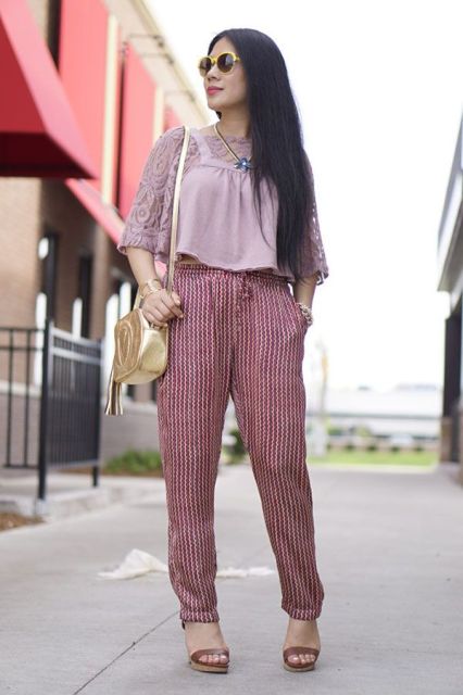 With printed trousers, platform sandals and golden bag