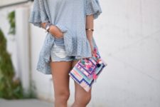 With ruffled shirt, distressed shorts and colorful clutch