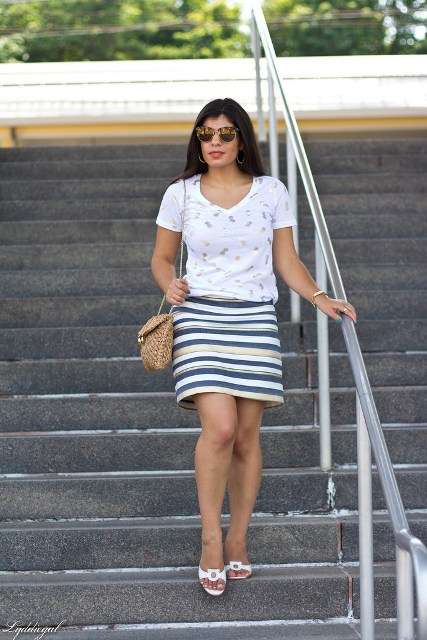 With striped skirt, white shoes and chain strap bag