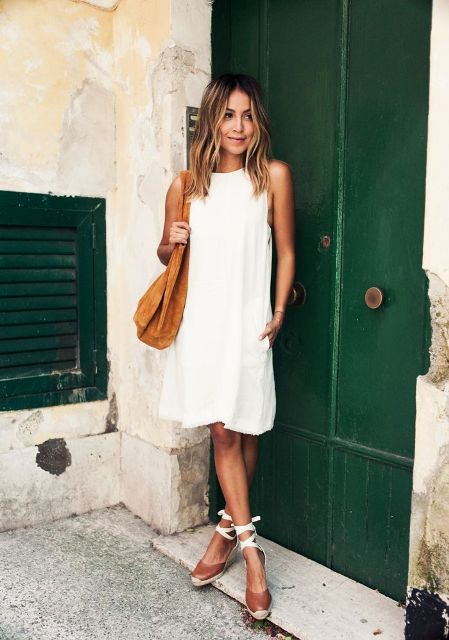 With white dress and brown suede bag