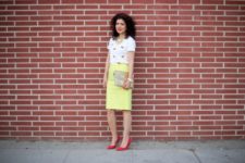 With yellow knee-length skirt, clutch and red pumps