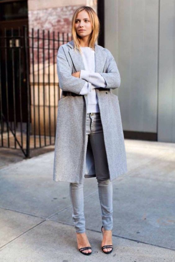 grey jeans, an off-white top, a grey coat and black heels for a simple modern look