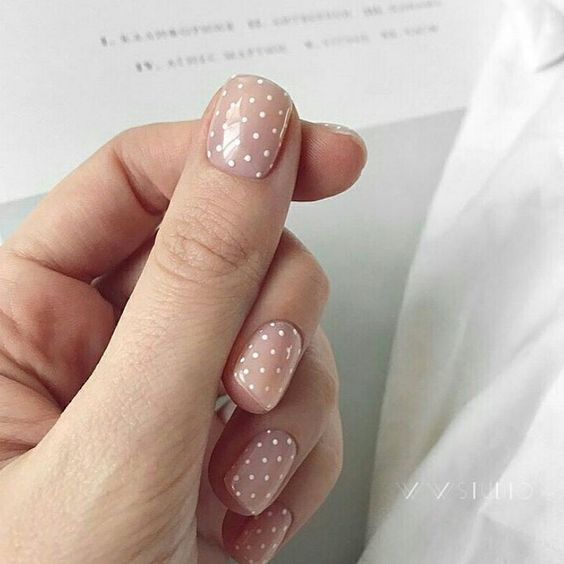 a nude manicure with white polka dots is a timeless and girlish idea to try