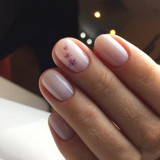 nude nails with little purple flowers are a very delicate and girlish option to rock