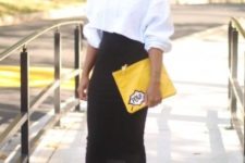 With black high-waisted midi skirt, yellow clutch and two colored shoes