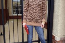 With cuffed jeans, red clutch and brown and black boots
