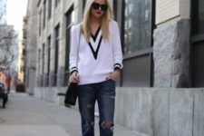 With distressed jeans, chain strap bag and black pumps