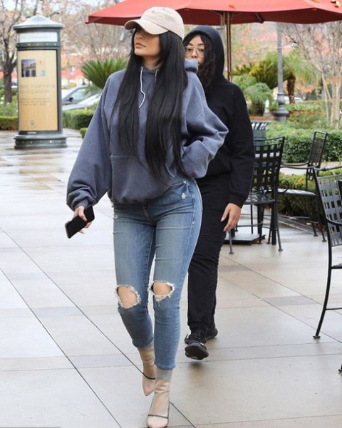 With gray cap, distressed jeans and ankle boots