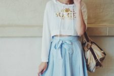 With light blue A-line skirt and beige bag