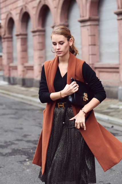 With pleated skirt, brown long vest and black bag