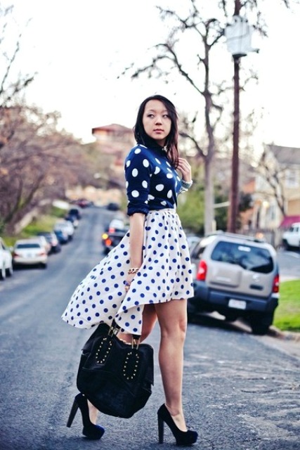 With polka dot skirt, black tote and high heels