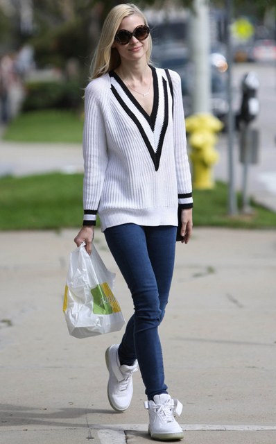 With skinny jeans and white sneakers