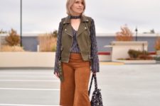 With striped shirt, olive green vest, beige ankle boots and leopard bag