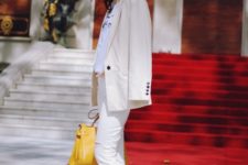 With t-shirt, beige blazer, pants and yellow bag