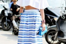With white crop top, blue clutch and flat sandals