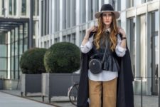 With white shirt, leather vest, wide brim hat, black coat and cutout ankle boots