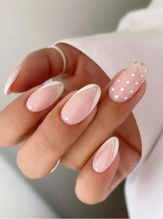 a fun version of Frenhc manicure on long lamond nails with white geo tips, polka dots and a single polka dot accent nail