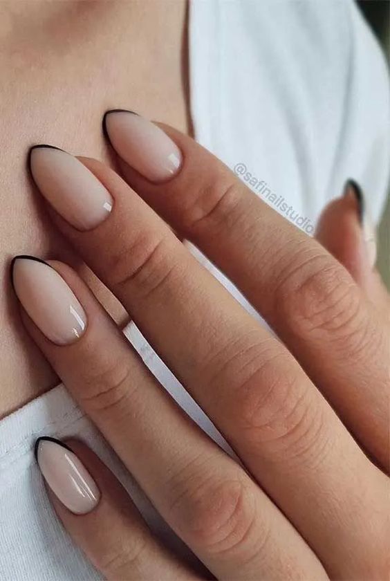 a minimalist French manicure done in vanilla and black, with super thin geometric black tips