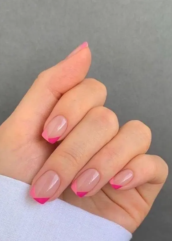 a short square manicure with a bright modern version of French nails, with hot pink and light pink geometric tips