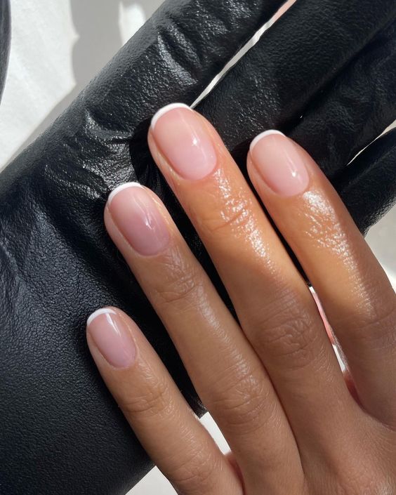 A stylish squoval French manicure in blush and white, with minimal tips, looks very up to date