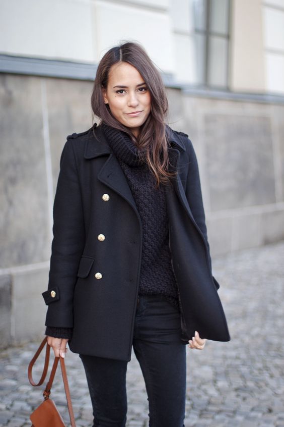 black jeans, a black chunky knit sweater, a black short coat and an amber bag for a cold day